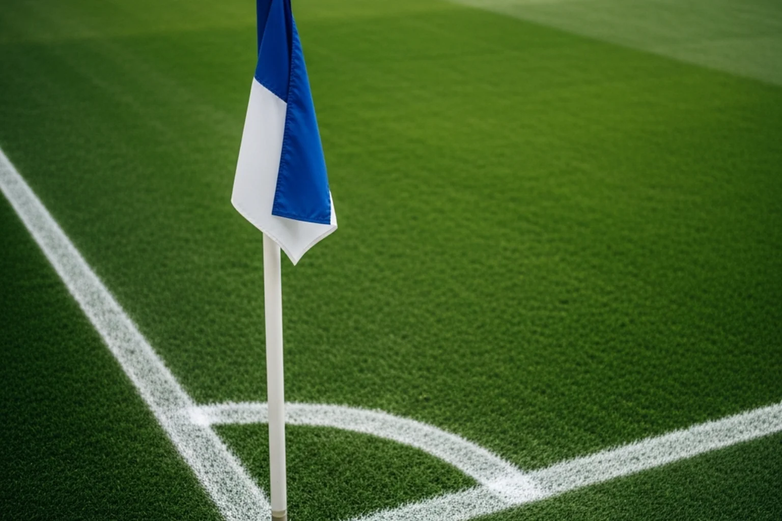 Banderín de córner de fútbol en la esquina de un campo profesional con césped verde